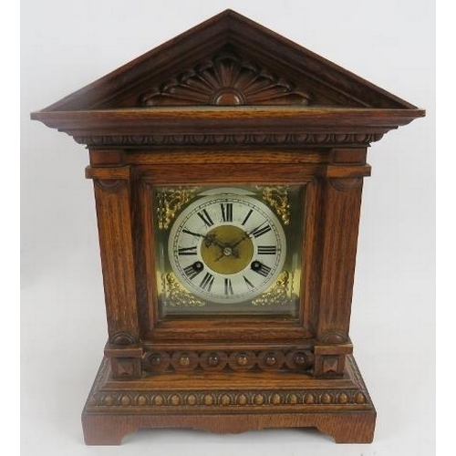 265 - Junghans mantle clock. Architectural oak case, coil strike, with key included. Bevelled glazed doors... 