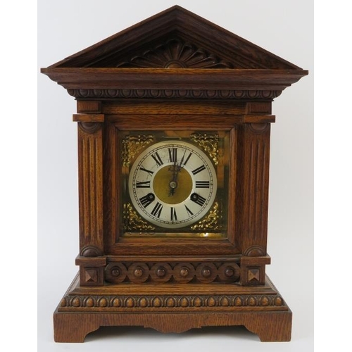 265 - Junghans mantle clock. Architectural oak case, coil strike, with key included. Bevelled glazed doors... 