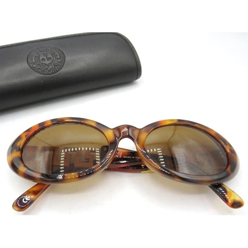 306 - A pair of Versace tortoiseshell effect sunglasses with gold coloured Greek key design pattern on the... 