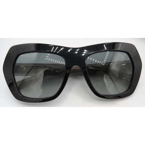 310 - A pair of Max Mara black sunglasses with gold coloured decoration on the transparent arms, cased.
Co... 