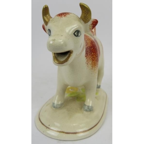 36 - A late Victorian ceramic Ayrshire cow creamer. Hand painted with gilt highlights and supported on an... 