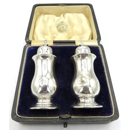 362 - A pair of silver pepper pots on pedestal feet, Birmingham 1911, cased. Approx 3