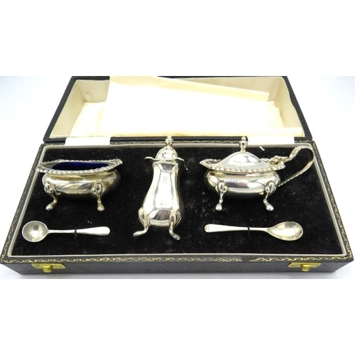 369 - A three piece silver condiment set on pad feet, Birmingham 1969, with silver salt and mustard spoon,... 