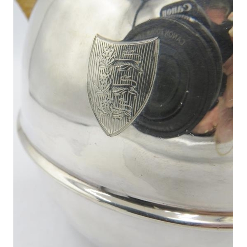 429 - A large silver Guernsey jug with wicker handle, London 1948, engraved shield. Approx 8