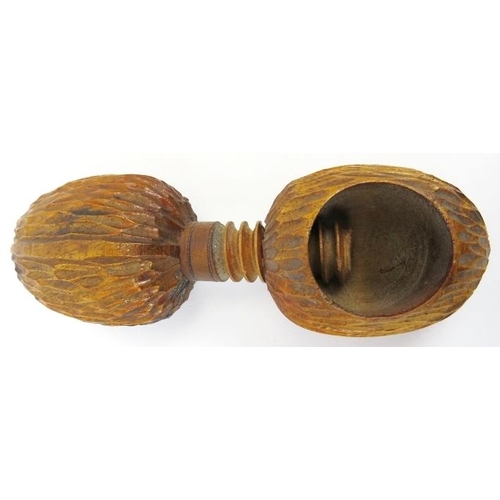 48 - A novelty treen nutcracker. The wood carved in the form of two oversized walnuts incorporated with a... 