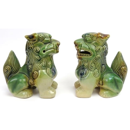 56 - A matched pair of sandai glazed ceramic Buddhistic lions. Both of similar form with incised and pier... 