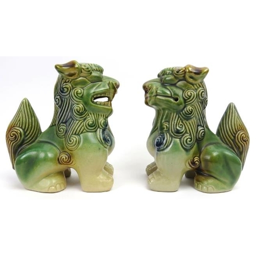 56 - A matched pair of sandai glazed ceramic Buddhistic lions. Both of similar form with incised and pier... 