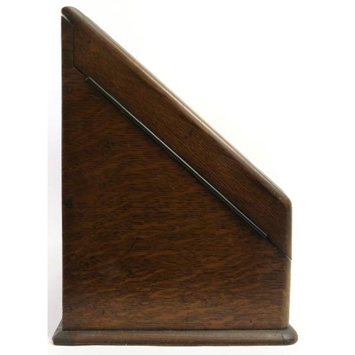 65 - - A Victorian oak letter rack. Of wedge form, the double hinged doors open to reveal sub divided int... 