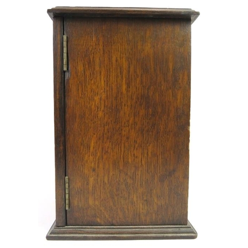 66 - An oak humidor, early/mid 20th century. The hinged door with lozenge glass front opens to reveal a h... 