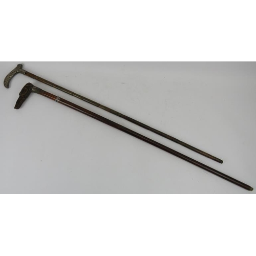 96 - Two Edwardian walking canes. Comprising a walking cane with a tapered shaft mounted with two silver ... 