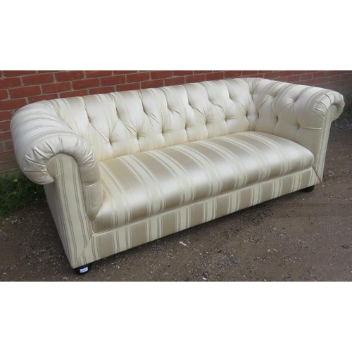 703 - A vintage three-seater chesterfield sofa, reupholstered in striped cream damask material, on ball fe... 