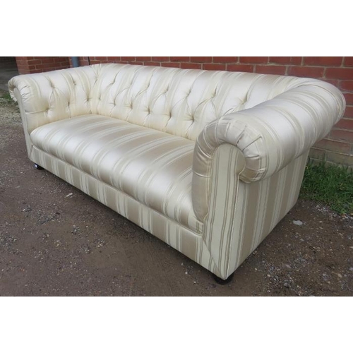 703 - A vintage three-seater chesterfield sofa, reupholstered in striped cream damask material, on ball fe... 