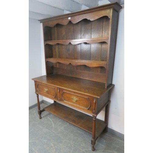 715 - A 19th century oak Welsh dresser in the 18th century taste, the plate rack shelving with shaped apro... 