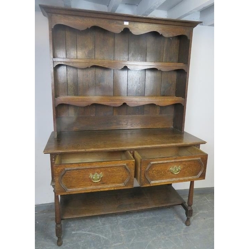 715 - A 19th century oak Welsh dresser in the 18th century taste, the plate rack shelving with shaped apro... 