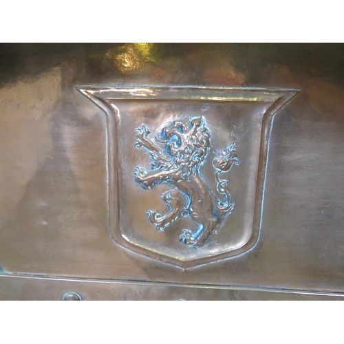 724 - An Arts & Crafts copper fire surround with banded and riveted detail and repousse central crest depi... 