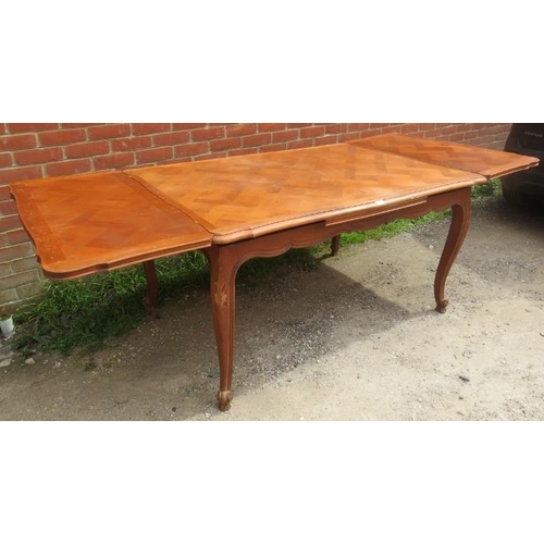 741 - A vintage French walnut draw-leaf extending dining table, the shaped top with parquetry inlay, on ac... 