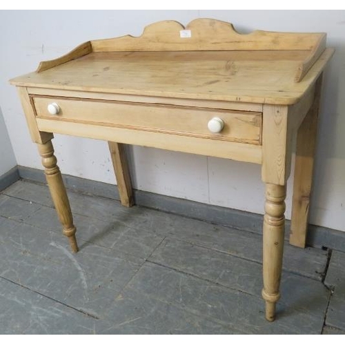 747 - An antique stripped pine washstand, with shaped ¾ gallery, housing one long drawer with ceramic knob... 