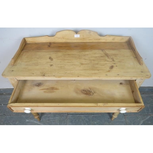 747 - An antique stripped pine washstand, with shaped ¾ gallery, housing one long drawer with ceramic knob... 