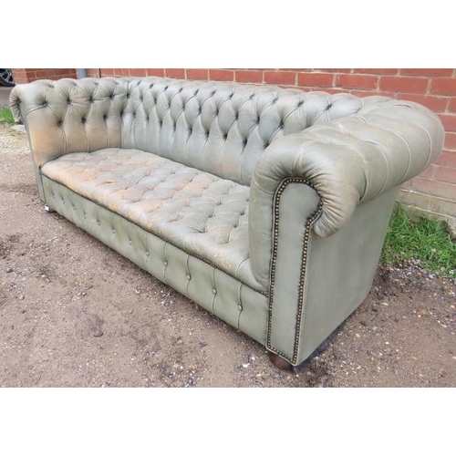 751 - A vintage three-seater Chesterfield sofa, upholstered in distressed grey leather with brass studs, o... 