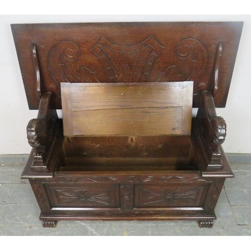 757 - A vintage oak monk’s bench, with lion armrests and carved front panels, including loose cushions in ... 