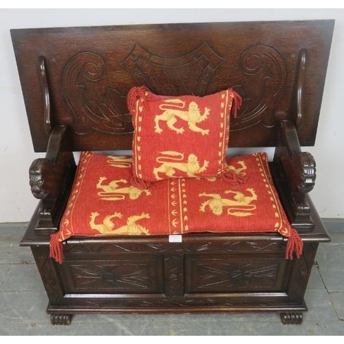 757 - A vintage oak monk’s bench, with lion armrests and carved front panels, including loose cushions in ... 