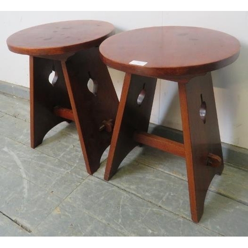 762 - A pair of Arts & Crafts circular mahogany side tables, on canted stile supports with pierced side de... 