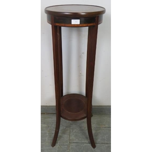 763 - An Edwardian mahogany circular two-tier plant stand, crossbanded and strung with satinwood, on splay... 