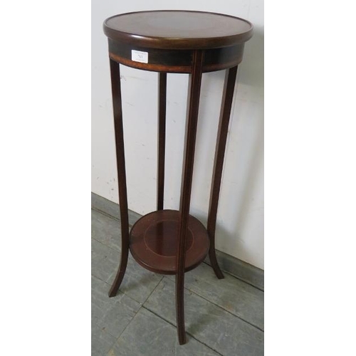 763 - An Edwardian mahogany circular two-tier plant stand, crossbanded and strung with satinwood, on splay... 