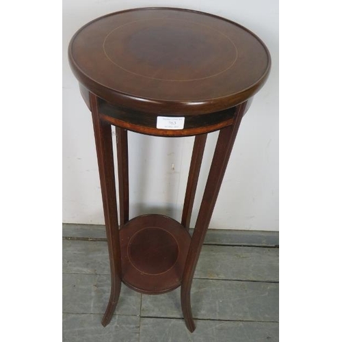 763 - An Edwardian mahogany circular two-tier plant stand, crossbanded and strung with satinwood, on splay... 