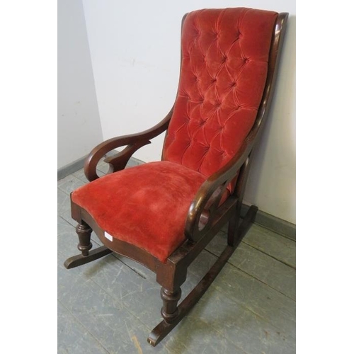 770 - A Victorian mahogany rocking chair with scrolled arms, upholstered in buttoned red velvet material, ... 