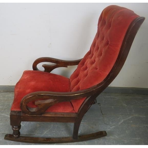 770 - A Victorian mahogany rocking chair with scrolled arms, upholstered in buttoned red velvet material, ... 