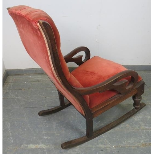 770 - A Victorian mahogany rocking chair with scrolled arms, upholstered in buttoned red velvet material, ... 