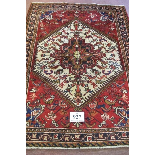 927 - A Persian Heriz rug, with a cream hexagonal central panel on a red ground. 168cm x 110cm (approx).