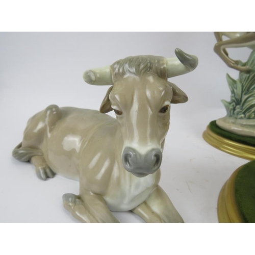 265 - A group of five Lladro figurines. Comprising a leaping gazelle, recumbent bull, recumbent donkey, go... 