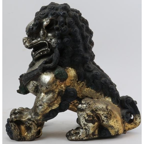 110 - A pair of Chinese silver and gold gilt and polychrome painted cast metal Buddhistic lions. (2 items)... 