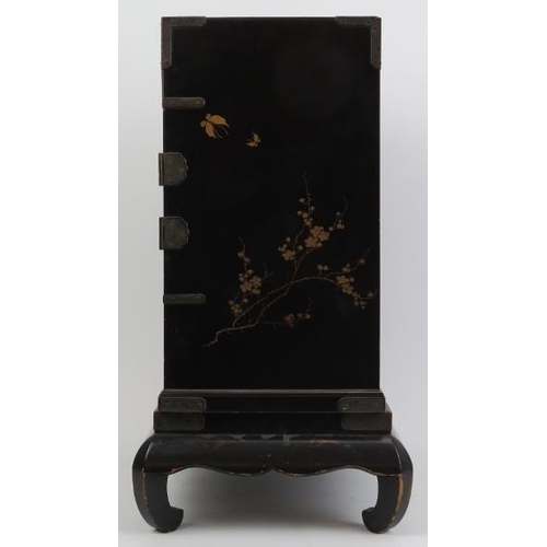 120 - A Japanese lacquered miniature cabinet on stand, Meiji/Taisho period. The hinged doors opening to re... 