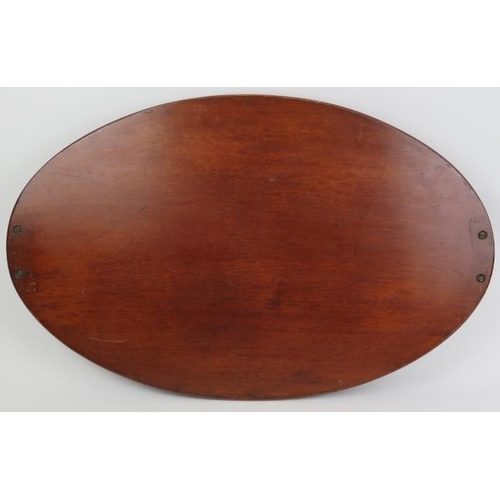 121 - A large Edwardian oval mahogany twin handled tray. With an outer gallery and central bats wing medal... 