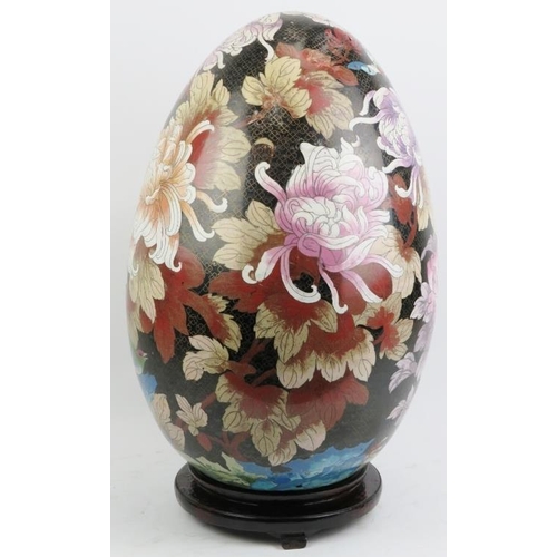 14 - A large Chinese cloisonné enamelled egg, 20th century. Decorated with an exotic bird amongst flowers... 