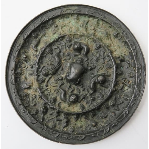 15 - Two Chinese bronze mirrors. In the Tang dynasty style with decoration cast in relief depicting a var... 