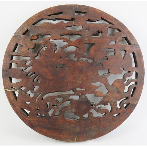 17 - A large Chinese carved wood roundel, 20th century. Carved in openwork depicting a dragon amongst clo... 