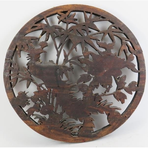 18 - A large Chinese carved wood roundel, 20th century. Carved in openwork depicting a peacock amongst fl... 