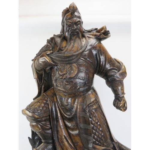 19 - A large Chinese carved wood figure of a warrior. Depicted standing above a dragon amongst clouds. 44... 