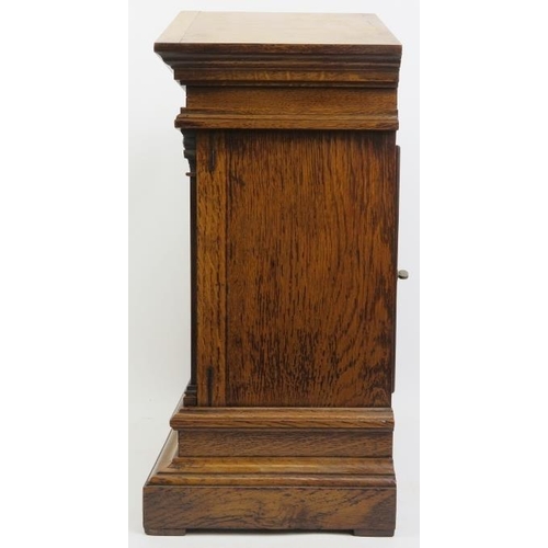 202 - An oak cased Palladian style mantel clock, late 19th/early 20th century. With a bevelled glass front... 