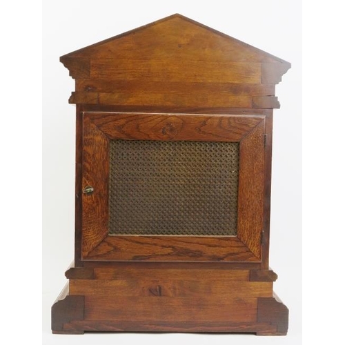 202 - An oak cased Palladian style mantel clock, late 19th/early 20th century. With a bevelled glass front... 