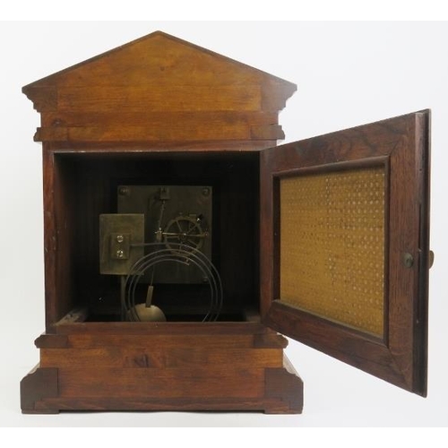 202 - An oak cased Palladian style mantel clock, late 19th/early 20th century. With a bevelled glass front... 