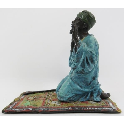 206 - A cold painted bronze praying Arab, 20th century. 5.5 in (14 cm) length. 
Condition report: Good ove... 