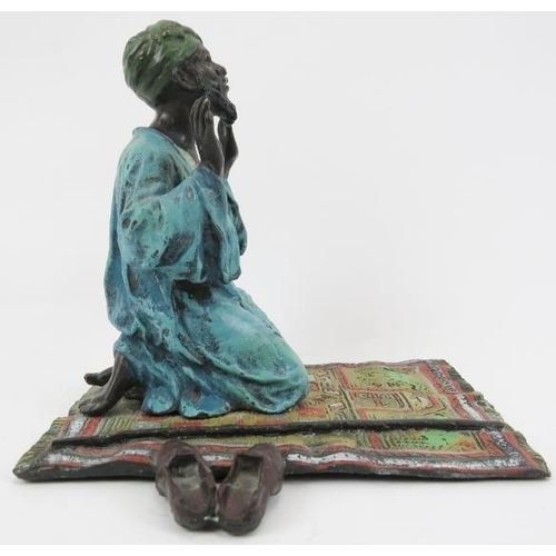 206 - A cold painted bronze praying Arab, 20th century. 5.5 in (14 cm) length. 
Condition report: Good ove... 