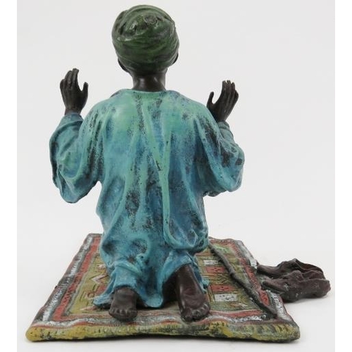 206 - A cold painted bronze praying Arab, 20th century. 5.5 in (14 cm) length. 
Condition report: Good ove... 