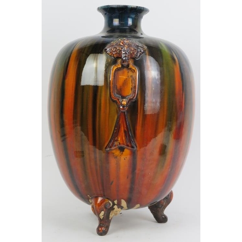 224 - An unusual European drip glazed twin handled vase. Of ovoid form and supported on tripod feet. 15.3 ... 