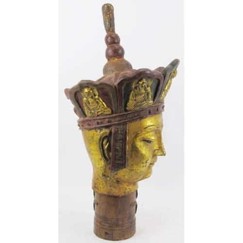 23 - A large Chinese gilt and lacquer painted bronze Buddha head. Supported on a cylindrical wood plinth.... 